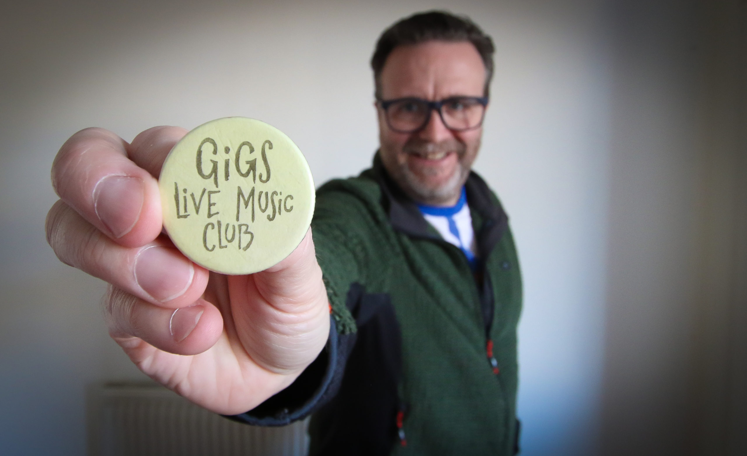 Andy Labrow holding a 'Gigs' badge